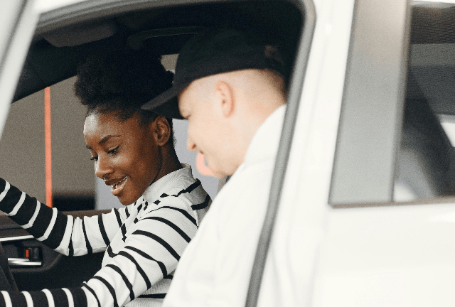 Accessible driving training blog - young women in drivers seat smiling with male instructor sat in the front passenger seat