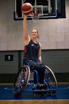 Robyn Love in sports wheelchair mid-shot on a basketball court 