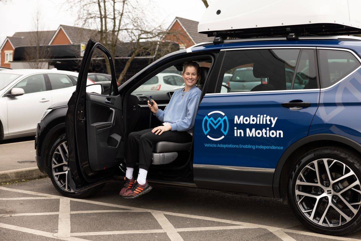 Robyn Love smiling sat on swivel seat in the front passenger side of Mobility i Motion demo car